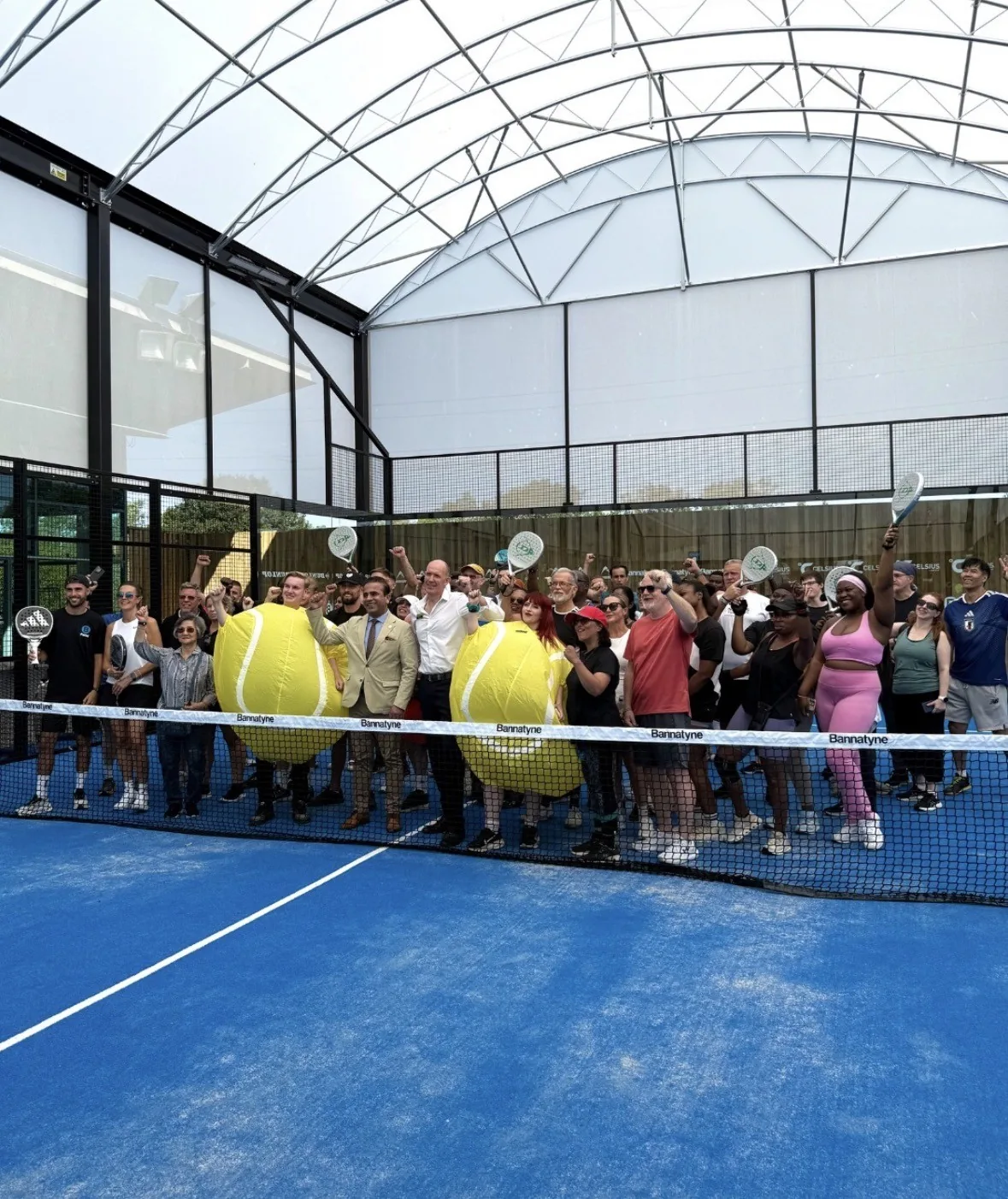 Large group event on a Bannatyne padel court with players in tennis ball costumes celebrating a Nick's activation