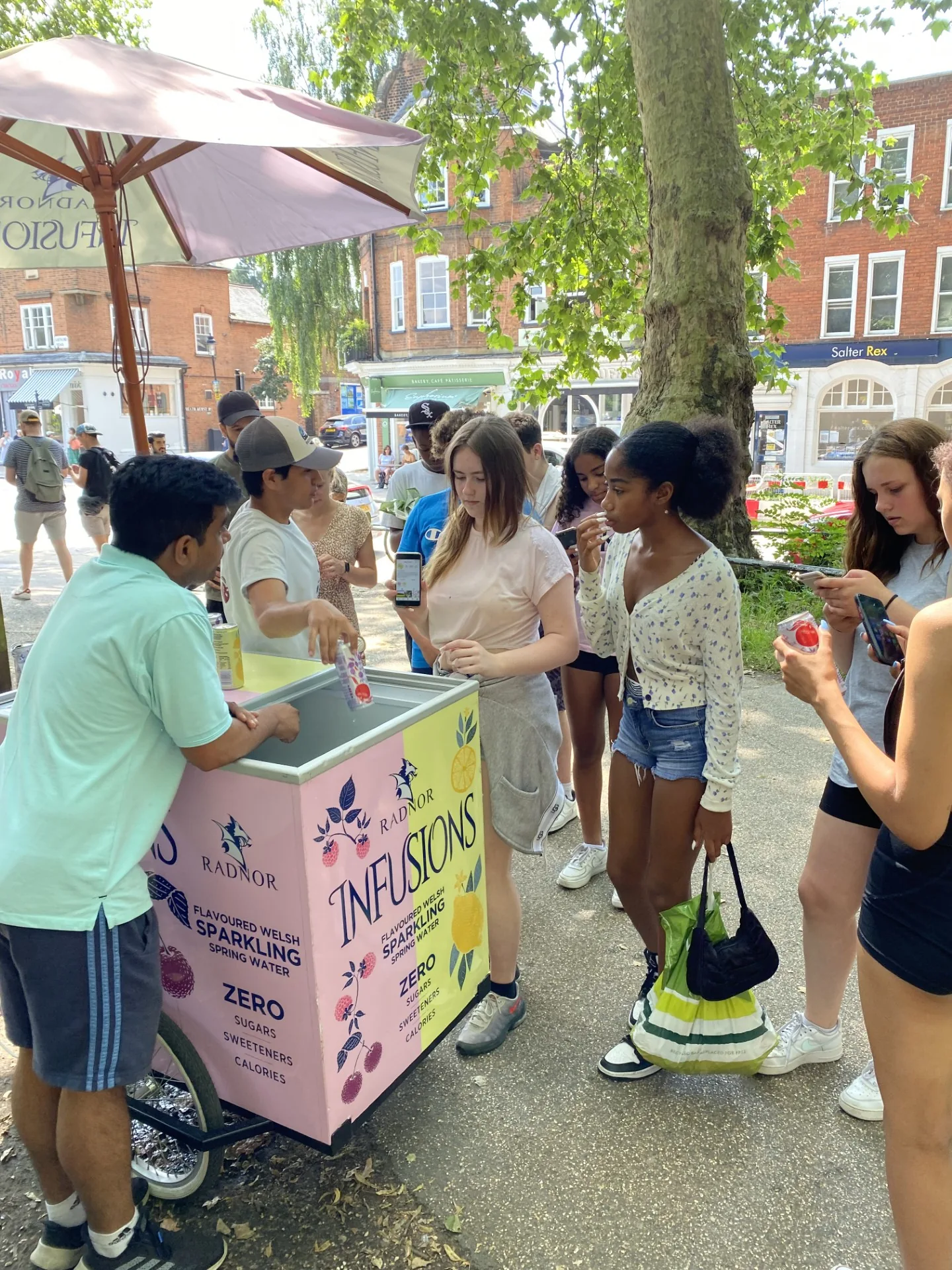 Crowd gathered around the Radnor Infusions sampling trike as FOTS ambassadors hand out cans on a busy high street