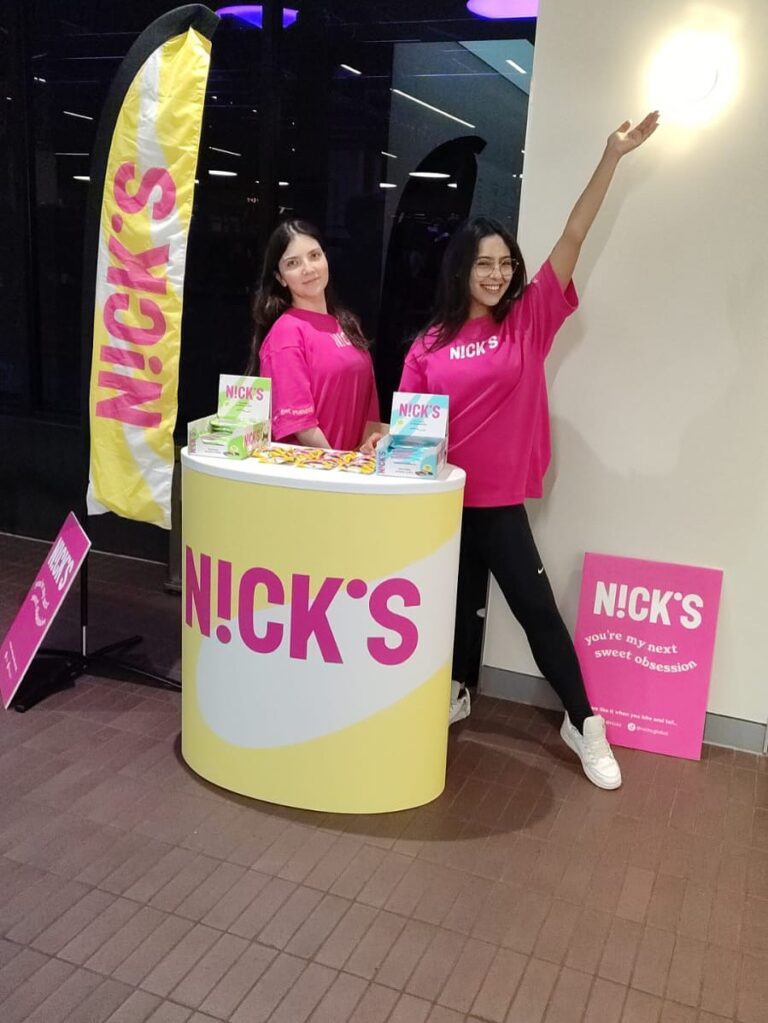 two brand ambassadors in pink shirts promoting nick’s products at event stand