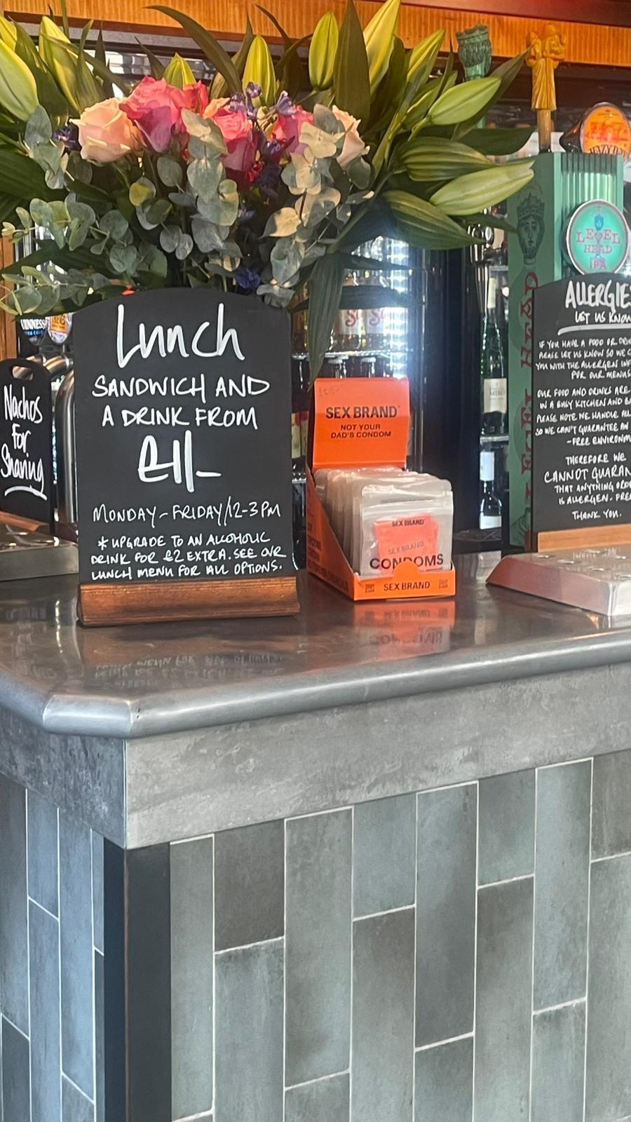 lunch sandwich and a drink sign on bar counter with flowers
